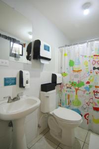 马那瓜La Bicicleta Hostal的浴室设有卫生间、水槽和淋浴帘