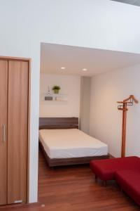 熊本Kumamoto - Apartment / Vacation STAY 76520的一间卧室配有一张床和一张红色的沙发
