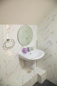 塔什干Ridon Lux Hotel的白色的浴室设有水槽和镜子