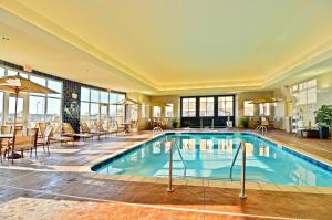 威利斯顿Holiday Inn Express & Suites - Williston, an IHG Hotel的酒店大堂的游泳池,配有桌椅