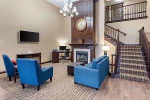 HeathComfort Inn & Suites Columbus East的客厅配有蓝色椅子和壁炉
