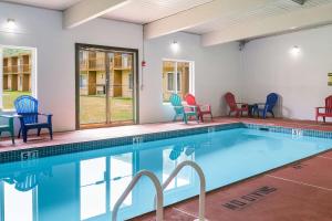 特拉华峡谷Fairmount Inn & Suites - Stroudsburg, Poconos的游泳池配有五颜六色的椅子和桌子