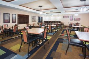 洛斯阿拉莫斯洛斯阿拉莫斯埃特拉达公园智选假日酒店的空的饭厅,配有桌椅