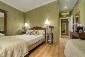 罗马BQ House Trevi Luxury Rooms的一间卧室配有一张床和一张鲜花桌