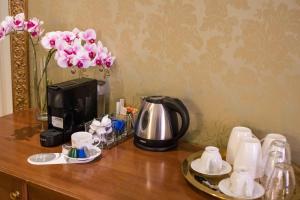 罗马BQ House Trevi Luxury Rooms的一张桌子、咖啡壶、咖啡壶和鲜花