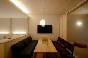 金泽so, KANAZAWA的带沙发、桌子和电视的客房