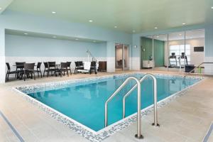 HermantownHoliday Inn Express & Suites Duluth North - Miller Hill, an IHG Hotel的游泳池位于酒店客房内,配有桌椅