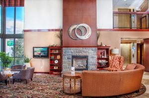 里奇兰Holiday Inn Express Hotel & Suites Richland的大堂设有壁炉、沙发和椅子。