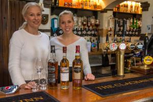 德里门The Clachan Inn的两名妇女站在酒吧后面,酒吧里放着葡萄酒