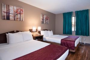 小石城Guest Inn & Suites - Midtown Medical Center的酒店客房,设有两张床和蓝色窗帘