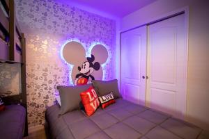 基西米Windsor at Westside的一间设有米老鼠卧室的房间,配有紫色照明