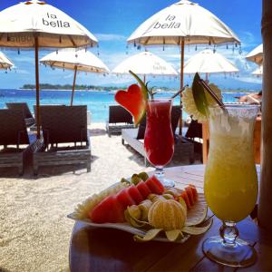 吉利特拉旺安La Bella - Hotel Villa & Spa的海滩上的一张桌子,上面放着两杯鸡尾酒和一盘食物