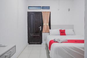明古鲁省RedDoorz near Jalan Soeprapto Bengkulu的客房设有两张床、一扇门和一扇窗户