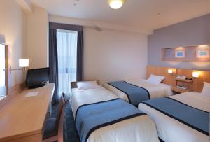 埼玉市浦和华盛顿酒店的酒店客房设有三张床和电视。
