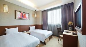 嘉义市冠阁商务大饭店的酒店客房设有两张床和电视。