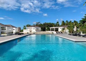 TabuelanCebu R Resort Tabuelan的一座房子前面的蓝色海水游泳池