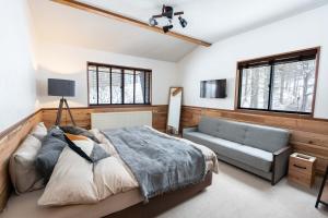 妙高Onpoint Madarao的一间卧室配有一张床、一张沙发和窗户。