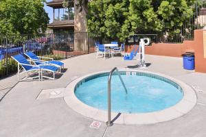 圣地亚哥圣地亚哥烛木套房酒店的一个带椅子和桌椅的小型游泳池