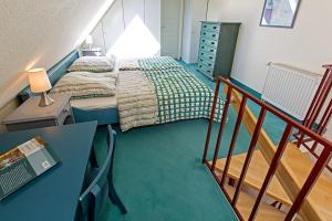 欧巴德伍斯图Ferienhaussiedlung Strandperlen Sanddornhof 3d (Typ I)的一间小卧室,配有一张床和一个楼梯