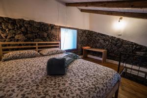 Aci BonaccorsiB&B La Casetta的一间卧室设有一张床和石墙