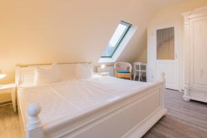 欧巴德伍斯图Ferienhaussiedlung Strandperlen Sanddornhof 3a (Typ VIII)的卧室配有一张大白色床和窗户