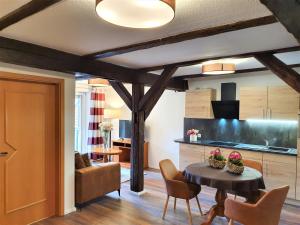 韦尼格罗德韦尼格罗德公寓酒店的厨房以及带桌椅的起居室。