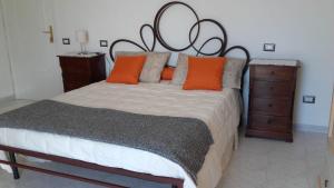 特拉蒙蒂La Casa in Vigna的一间卧室配有一张带橙色枕头的大床