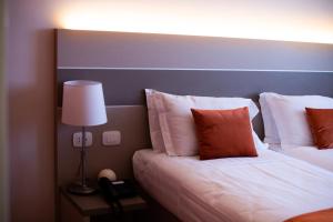 圣毛罗托里内塞格利斯酒店的酒店客房,设有两张床和一盏灯