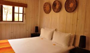 MaanhaarrandIntaba Thulile的一间卧室配有带白色床单和枕头的床。