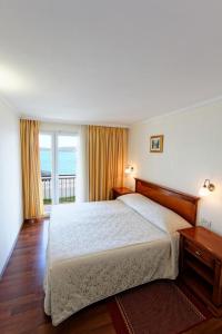 特罗吉尔Hotel Val All Inclusive的一间卧室配有一张床,享有海景