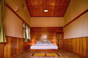 穆克缇斯瓦Enchanted Hills Farmstay的卧室配有一张床铺,位于带木墙的房间内