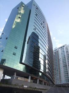 巴西利亚VISION Flat Particular Varanda Garagem Piscina Academia的一座高大的玻璃建筑,在城市里