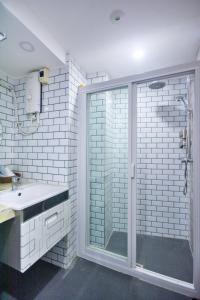 长滩岛Emerald Island Hotel的一间带玻璃淋浴和水槽的浴室