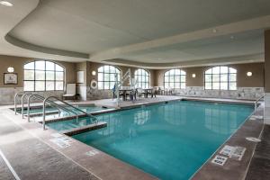 Altoona欧克莱尔阿尔图纳驻桥套房假日酒店的大楼内的一个蓝色海水游泳池