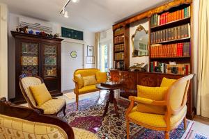 马萨Le Ginestre的客厅设有黄色椅子和书架