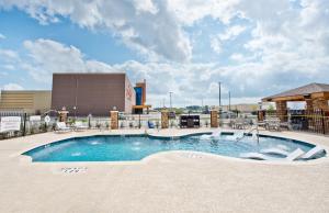 亨博尔Staybridge Suites Houston - Humble Beltway 8 E, an IHG Hotel的一座带大楼的度假村的游泳池