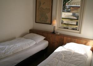SchoorldamRekerlanden 257的带窗户的客房内的两张床
