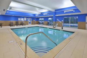 南希尔Holiday Inn Express and Suites South Hill, an IHG Hotel的蓝色墙壁的大房间设有一个游泳池