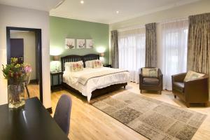 约翰内斯堡Sandown Guest House的卧室配有一张床和一张桌子及椅子