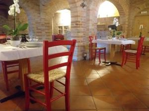 萨尔纳诺HOTEL B&B RESORT Fonte La Castellana的一间设有两张桌子和红色椅子的用餐室