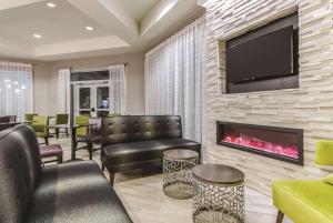 大章克申La Quinta by Wyndham Grand Junction Airport的客厅设有壁炉和平面电视。