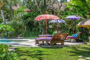 乌布斯瓦斯提生态别墅酒店的游泳池畔的桌椅和遮阳伞