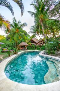 乌布斯瓦斯提生态别墅酒店的棕榈树度假村前的游泳池