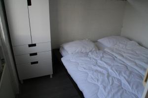 SchoorldamRekerlanden 195的一间小卧室,配有一张床和一个梳妆台