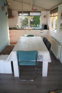 SchoorldamRekerlanden 195的厨房配有白色的桌椅
