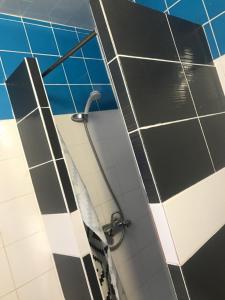 巴黎FM酒店的浴室铺有黑白瓷砖,配有淋浴