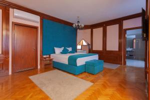 贝尔格莱德朱果斯拉维亚加尔尼酒店的一间卧室设有一张床和蓝色的墙壁