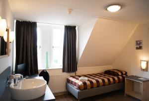 Hedel海德尔斯旺酒店的一间带水槽、床和窗户的浴室