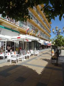 多列毛利诺斯Hotel Torremolinos Centro的一组桌子和椅子,位于大楼前