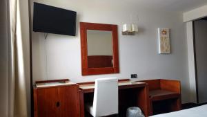 埃斯基维亚斯伊达尔戈酒店的一间卧室配有一张带镜子的桌子和一台电视